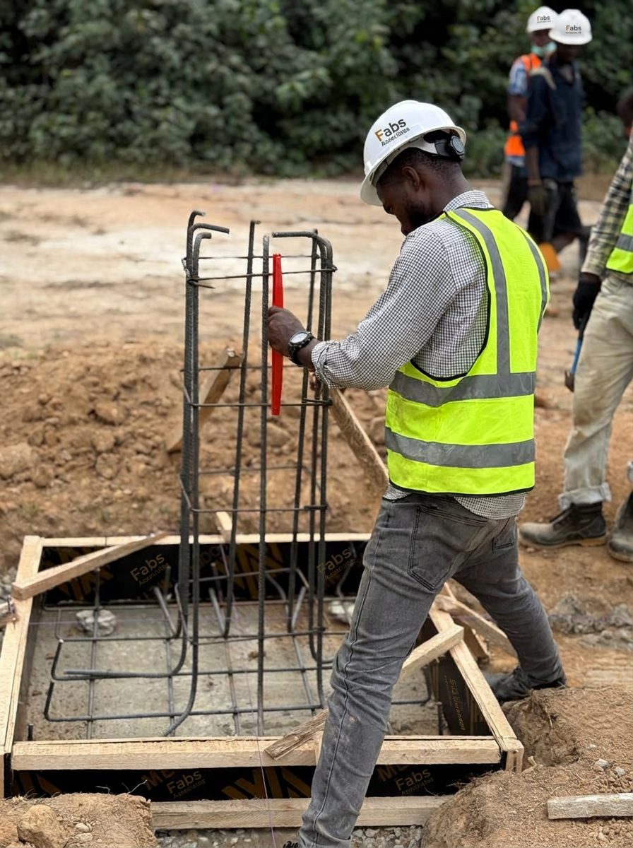 Construction team checking steel reinforcement on site, wearing hard hats and high-visibility vests